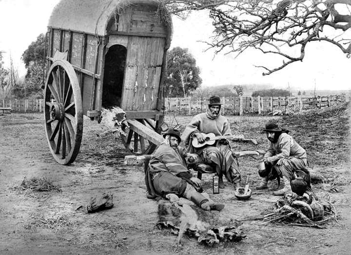 Francisco Ayerza. Grupo de gauchos junto a una carreta, con guitarra y mate. Fines del siglo XIX, según la identificación de Tan sólo hallé la tapera. Reproducción tomada del capítulo III, p. 235. La fuente adjunta no precisa la fecha exacta ni la signatura del original. (Ayerza, s. f.)